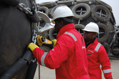 Fendercare men securing chains on fender