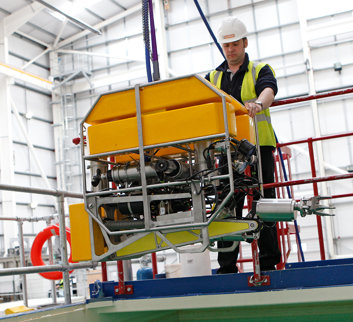 Two JFN employees operate remote tool for nuclear pond clear up