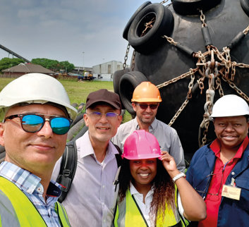 A horizontally flipped image of Fendercare Marine's, Marine Technical Director and Fendercare crew in front of a fender